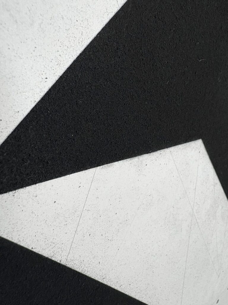 Detail of Caretaker (Glyph Drawing No. 5), showing an even, sandy, tactile texture, interrupted by a sharp white triangular shapes of the underlying paper with faint graphite grid lines.