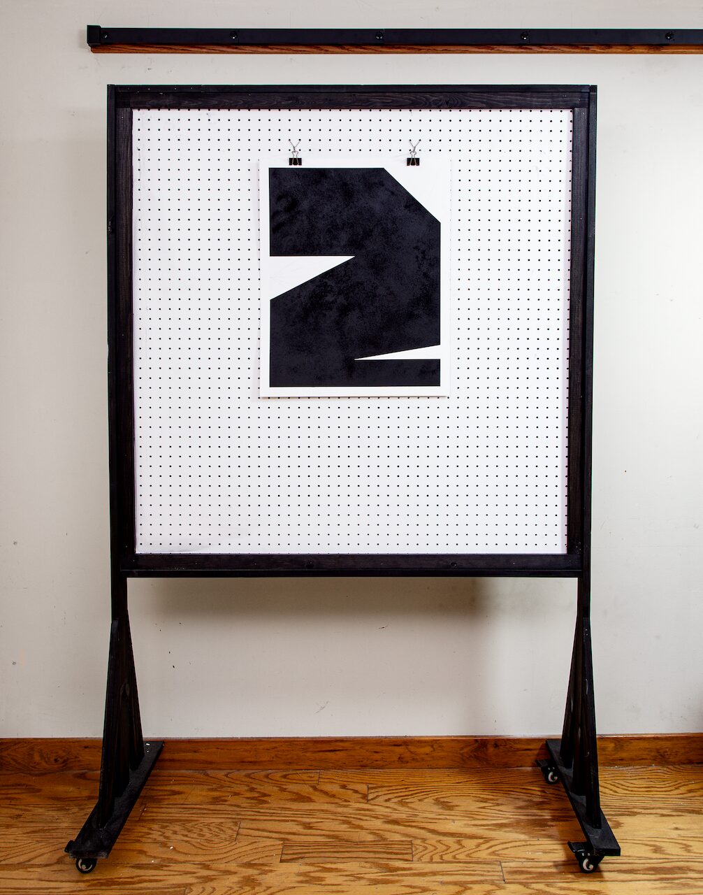 Minimalist wide shot of Untitled, Drawing No. 3 hanging on a white pegboard wall in the artist’s studio, with hardwood floors and a white wall in the background.