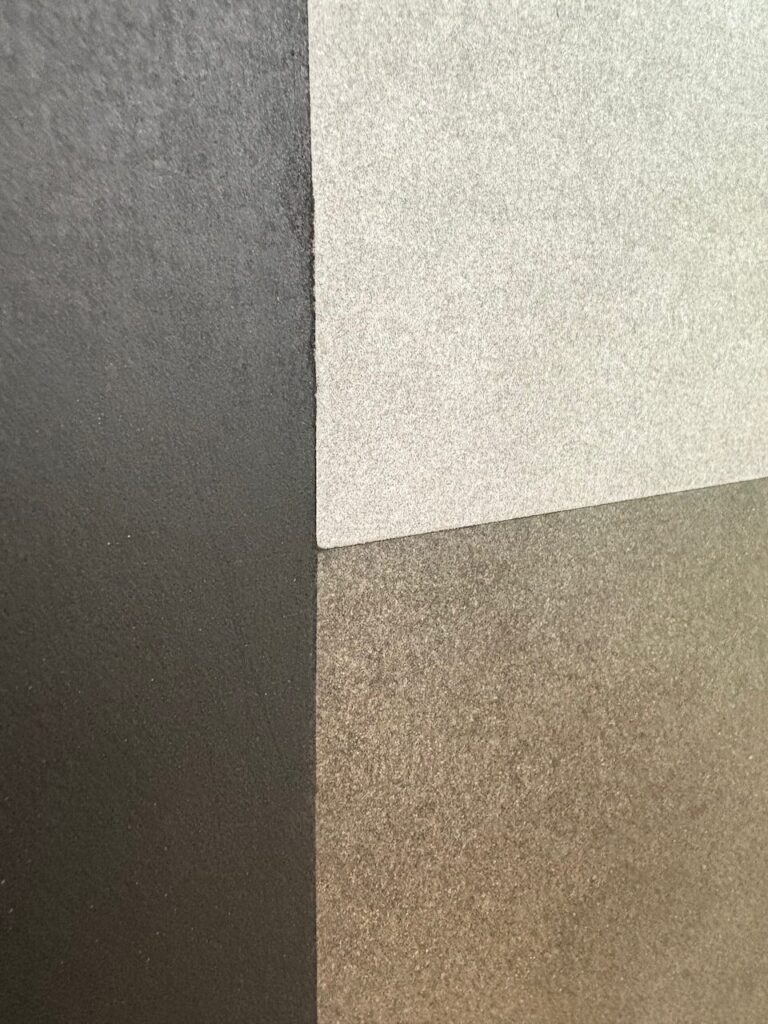 Extreme close-up of Rectangles and Squares, No. 2, highlighting the smooth charcoal background, visible grid lines, and precise tonal application of the pale graphite and medium-gray squares, emphasizing material control and subtle visual tension.